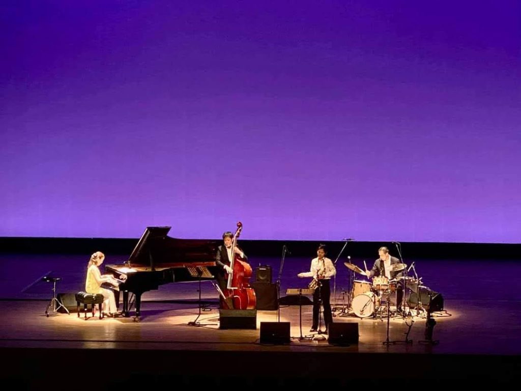 長崎市内の高校の芸術鑑賞会にて、ホールの大舞台でカルテット編成でジャズを演奏する小笠原由美