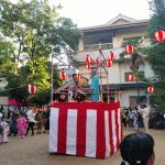 幼稚園敷地内グラウンドにて盆踊り。チンドンかわち家が太鼓を叩き、音頭を取っている